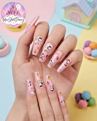 Hand mit Snoopy-Nagel-Stickern, bunte Motive auf rosa und weißem Grund