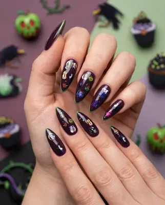 Hand mit langen, dunkelvioletten Nägeln, verziert mit schwarzen und glitzernden Schurken-Motiven