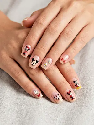 Fingernägel mit Disney-Motiven: Mickey und Minnie in Rot, Schwarz und Gold auf hellem Untergrund