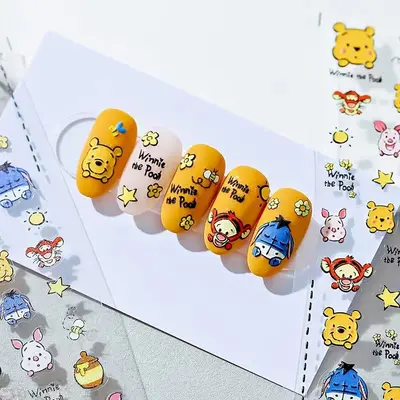 Winnie Puuh Nagelsticker auf gelben Nägeln, verschiedene Motive mit Bär und Freunden