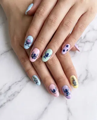 Fingernägel mit bunten Stitch-Motiven in Blau, Rosa und Gelb auf weißem Grund