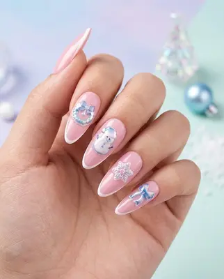 Hand mit rosa Nägeln, darauf blaue und weiße Weihnachtsmotive wie Schneeflocken und Weihnachtskugeln