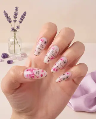 Hand mit aufgetragenen Nagelaufklebern in Rosa und Weiß mit Blumenmotiven