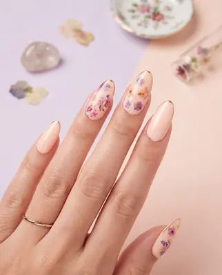 Fingernägel mit 3D-Blumenstickern, Blüten in Rosa und Violett auf hellbeigem Untergrund