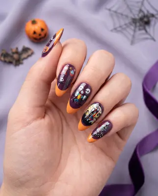 Hand mit aufgetragenen Disney Jack & Sally Nagelstickern in Lila und Orange mit glitzerndem Design