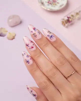 Fingernägel mit aufgeklebten bunten Blümchen-Motiven in Rosa, Violett und Creme