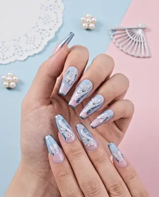 Hand mit langen Nägeln in Pastelltönen, verziert mit 5D-Stickern in Charakter-Motiven