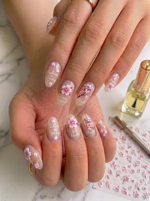 Nagellack mit 3D-Blumenmotiven in Rosa und Weiß auf natürlichen Nägeln