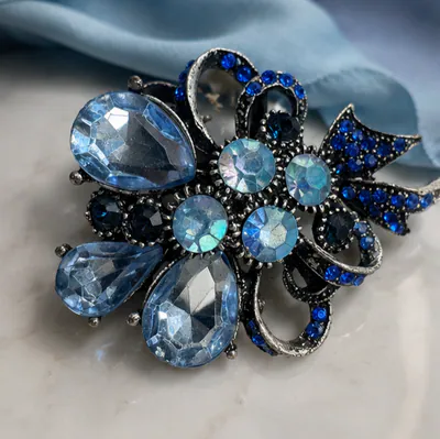 sehr schöne silberfarbende Brosche mit blauen , klaren Steinen - Größe 4,5 cm